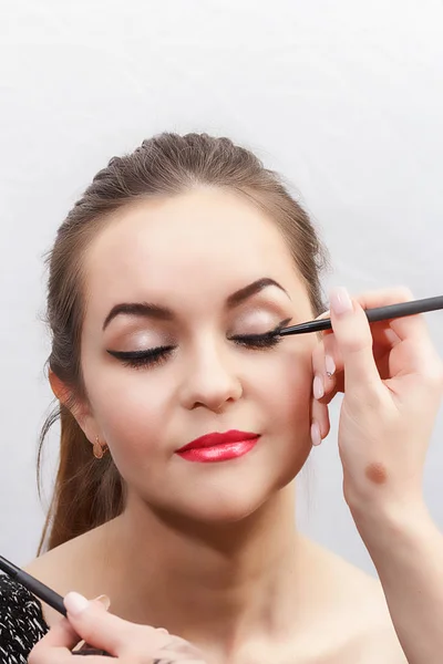 Make-up artist make eye make-up, arrows on eyes, close-up — Stock Photo, Image