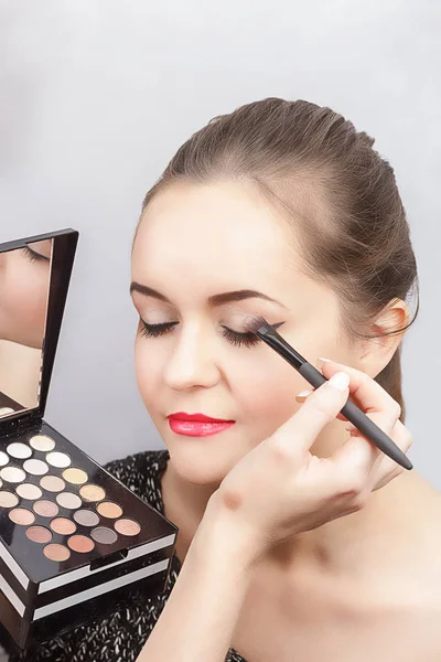 Make-up artist doing eye makeup, close-up. A palette of eye shadows in the hands of a make-up artist — Stock Photo, Image