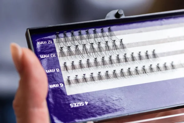 A set of artificial eyelashes of four sizes in a female hand