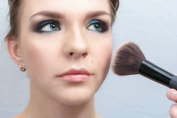 Processo de aplicação de maquiagem no rosto das meninas close-up. Aplicação de pó com uma escova especial — Fotografia de Stock