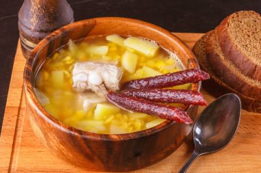 Bezelye çorbası ile patates, Domuz kaburga ve ahşap bir tabak içinde turşu sosis. Yakın çekim