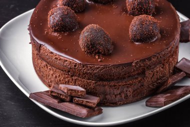 Ev yapımı çikolatalı bisküvi kek ve beyaz bir plaka üzerinde koyu çikolata parçaları