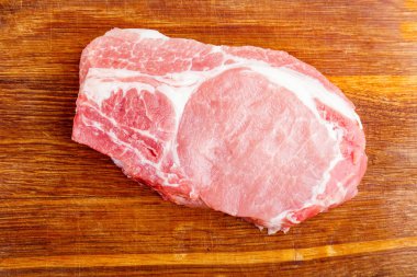 Bir ahşap kesme tahtası üstten görünüm üzerinde doğal pirzola Çiğ domuz eti