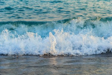 Dalga deniz, su, köpük çalışır gün batımında shore üzerinden. Arka plan. Doku