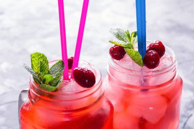 Berry Morse, frenk üzümü ve yabanmersini buz ve pudra şekeri ile kokteyl içme kavanozlara ile taze nane yaprakları ile kokteyl içme payet beton tablo yakın çekim üzerinde renkli.