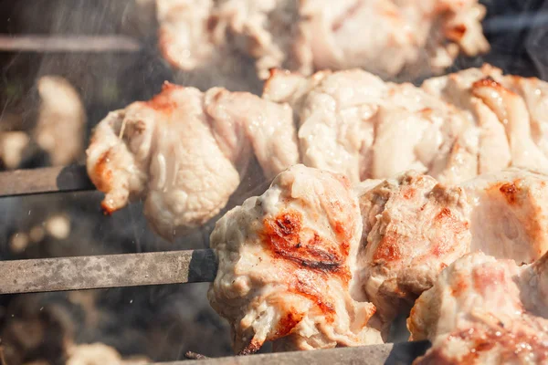 Кусочки мяса на шашлыках, жарящиеся на гриле. Шашлык, барбекю, свинина . — стоковое фото