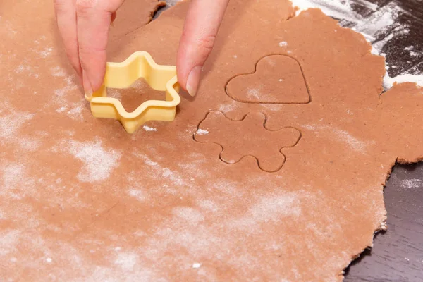 Corte de figuras da massa usando stencils especiais para fazer biscoitos de Natal de gengibre. Mãos femininas de perto. Casa, família se preparar para o conceito de férias — Fotografia de Stock