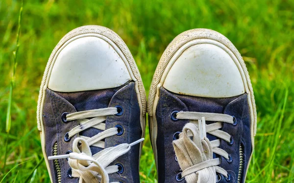 Régi, koszos, kopott cipők a zöld füvön. Túrázás utazási koncepció — Stock Fotó