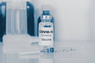 Coronavirus aşısı. Tıbbi konsept. Ampul ve şırınga. Kopyalama. mavi tonlama