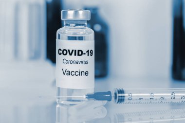 Coronavirus aşısı. Tıbbi konsept. Ampul ve şırınga. Kopyalama. mavi tonlama