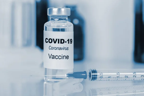Coronavirus aşısı. Tıbbi konsept. Ampul ve şırınga. Kopyalama. mavi tonlama