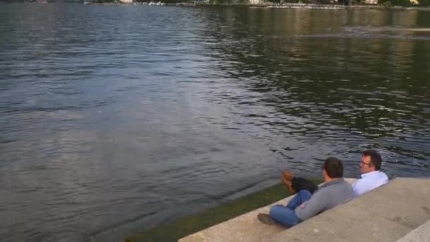 Verão pôr do sol famoso como lago dois homens falando na baía 4k itália — Vídeo de Stock