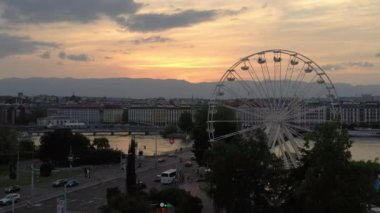 Akşam saatinde İsviçre 'de Cenevre şehir manzarasının dönme dolaplı 4k görüntüsü  