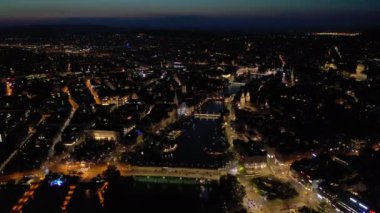 Gece vakti Zürih şehir manzarasını aydınlattı. Hava manzarası 4k İsviçre