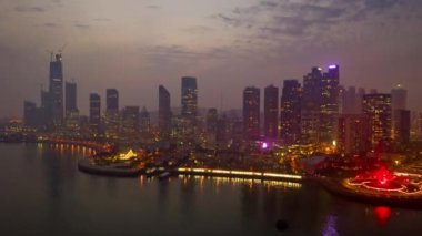 Gece aydınlatması şehir merkezindeki Qingdao şehrinin havacılık panoramasını gösteriyor 4k porselen.