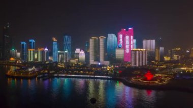 Gece aydınlatması şehir merkezindeki Qingdao şehrinin havacılık panoramasını gösteriyor 4k porselen.