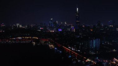 Nanjing şehrinin aydınlatılmış hava panorama 4K görüntüleri üzerinde gece uçuşu