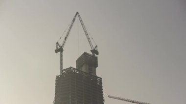 Gün batımında Qingdao şehri gökdelen inşaatında çalışıyor.