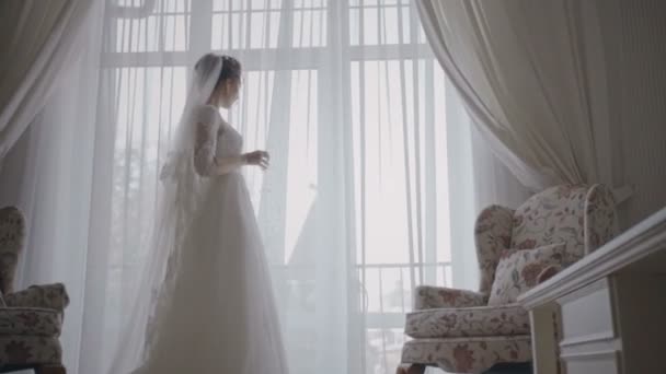 La mariée regarde par la fenêtre, le jour du mariage — Video