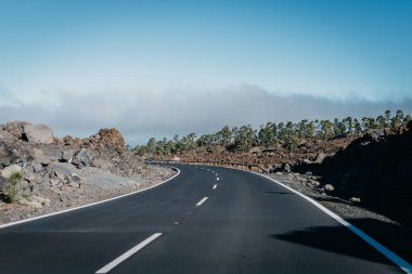 Otoyol bulutlar yakınındaki kayaların sola geçer. Teide Milli Parkı. Tenerife