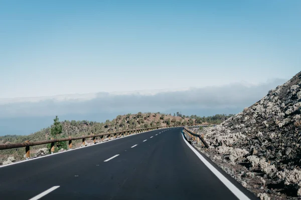Bulutlar yakınındaki kayaların karayolu geçer. Teide Milli Parkı. Tenerife