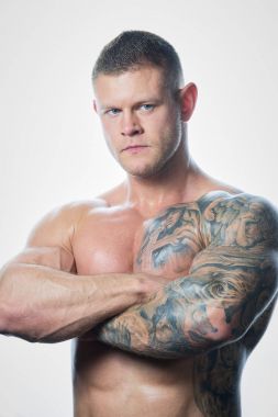 Kas gömleksiz adam mavi gözleri ve uzak beyaz arka plan üzerinde seyir dövme