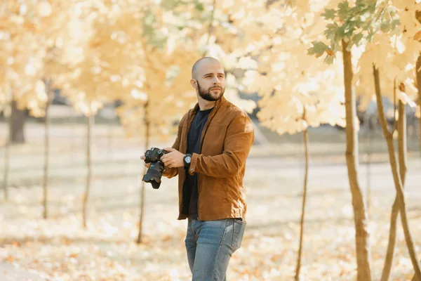 수염을 대머리의 작가는 스웨이드 재킷을 셔츠와 청바지를 카메라를 오후에 공원을 — 스톡 사진
