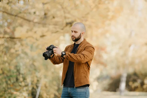 금발의 작가가 스웨이드 재킷을 셔츠와 청바지를 카메라를 사진을 바라본다 — 스톡 사진