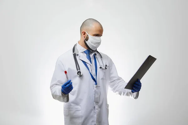 彼の手にコロナウイルスの血液検査に関する情報を読んでいる医療面のマスクの医者 感染症の医師の肖像画肯定的なCovid 19の血液サンプルとクリップボードを保持 — ストック写真