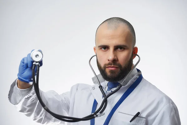 Médico Sério Segurando Estetoscópio Sua Mão Uma Luva Médica Azul — Fotografia de Stock