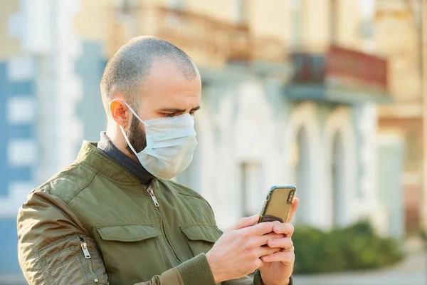 Mężczyzna Używający Smartfona Nosi Maskę Medyczną Uniknąć Rozprzestrzeniania Się Koronawirusu — Zdjęcie stockowe