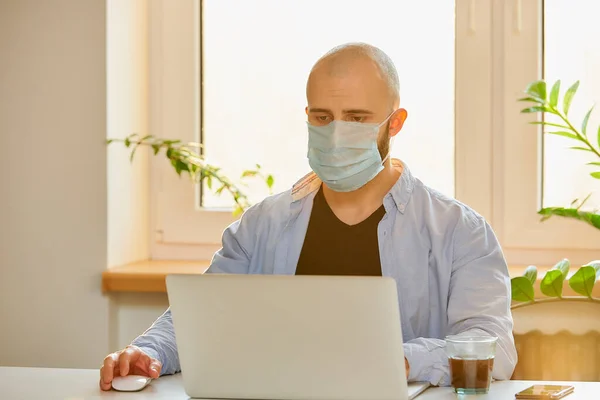 의료용 마스크를 남자가 확산되는 코로나 바이러스를 피하기 노트북에서 원격으로 작업을 — 스톡 사진