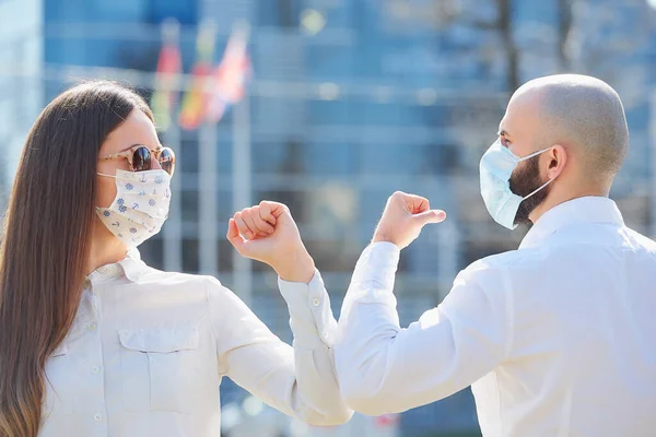 Dirsek çarpması. Coronavirus 'un (COVID-19) yayılmasını önlemek için dirsek seği selamı. Bir kadın ve bir erkek çıplak elleriyle sokakta buluşuyorlar. El sıkışarak ya da sarılarak selamlamak yerine, dirseklerini vururlar..