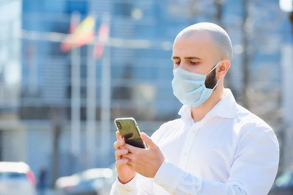 Łysy Człowiek Robiący Interesy Smartfonem Nosi Maskę Medyczną Uniknąć Rozprzestrzeniania — Zdjęcie stockowe