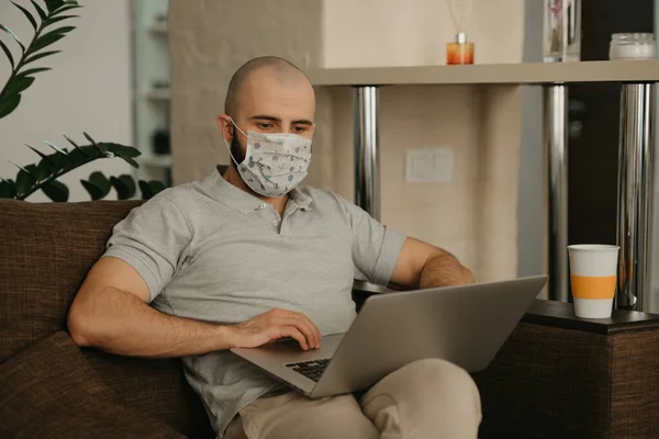 검시관 마스크를 남자가 확산되는 코로나 바이러스를 피하기 노트북으로 원격으로 연구하고 — 스톡 사진