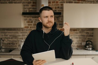 Uzaktan kumanda. Tabletinin üzerinde uzaktan çalışan sakallı bir adam. Bir iş adamı, iş arkadaşlarıyla bir video konferansı hakkında konuşmayı durdurdu.. 