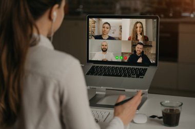 Çevrimiçi bir toplantı sırasında iş arkadaşlarıyla video konferansında uzaktan çalışan bir kadının arka planı. Video görüşmesinde ortağız. Çok ırklı iş adamları çevrimiçi bir toplantıda tartışıyorlar.