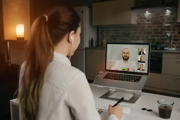 Rearview of businesswoman in a video conference with her boss and colleagues during an online meeting. Man in a video call with partners. Multiethnic business team having a discussion in a video call