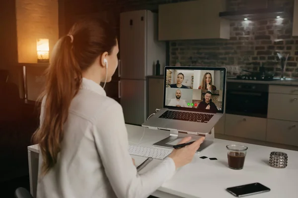 Memleketteki bir bilgisayardaki video konferansında meslektaşlarıyla iş hakkında uzaktan konuşan bir kadın çalışanın arka planda görüntüsü. Çevrimiçi bir toplantıda çok ırklı bir iş ekibi.