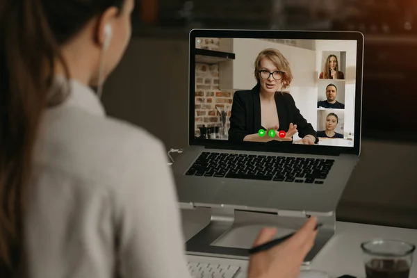 여자가 노트북으로 비디오 통화를 하면서 상사와 동료들 이야기하는 모습을 뒤에서 — 스톡 사진