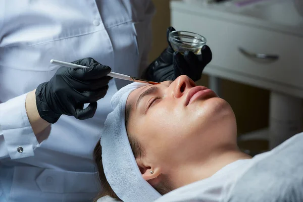 Eine Kosmetikerin Mit Schwarzen Medizinischen Einmalhandschuhen Verwendet Einen Pinsel Einer — Stockfoto
