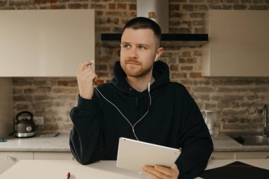 Uzaktan kumanda. Tabletinin üzerinde uzaktan çalışan sakallı bir adam. Bir iş adamı, iş arkadaşlarıyla bir video konferansı hakkında konuşmayı durdurdu.. 