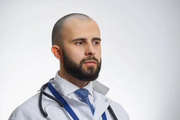 髭を生やした医者の肖像画だ 白い研究室のコート 青いネクタイ 聴診器の医師 — ストック写真