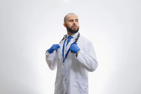 Lekarz Pozuje Jednorazowych Rękawiczkach Medycznych Trzymając Stetoskop Łysy Lekarz Brodą — Zdjęcie stockowe