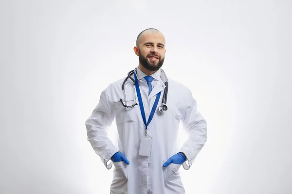 ポケットに手を握って聴診器を持つ使い捨て医療用手袋の幸せな医師 ひげを生やした医者が患者を診察する準備をしている — ストック写真