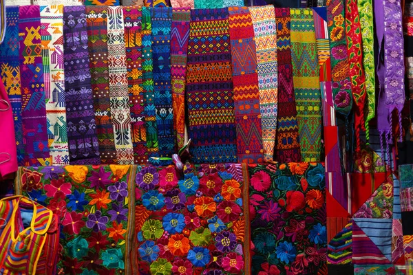 Typical Guatemalan fabrics spread in the market- fabrics with colorful designs of traditional Guatemalan flowers - Antigua Guatemala