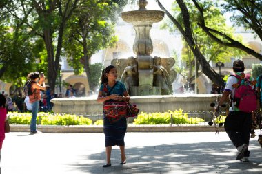 Guatemalalı kız Antigua Guatemala 'nın merkez parkında tipik kostümlü satıyor.