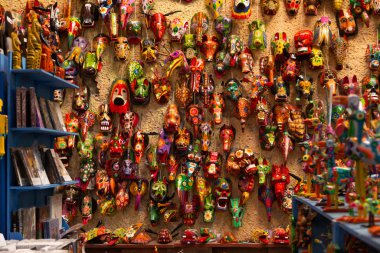 Antigua Guatemala 'da el boyaması maskelerle dolu bir duvar. Guatemala' nın geleneksel renkleri.