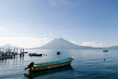 Arka planda Atitlan yanardağı, Guatemala 'daki göl tekneleri - dağlarla ve volkanlarla çevrili mavi göl - Atitlan gölünde gün doğumu
