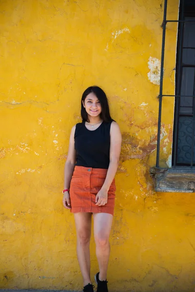 Fille voyageuse dans la ville coloniale - Femme hispanique debout devant un vieux mur jaune - Jeune femme pose dans les rues de la ville historique Guatemala — Photo